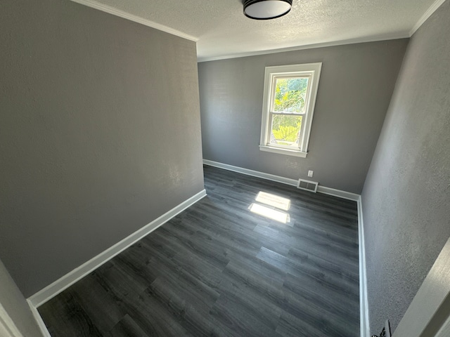 empty room featuring dark hardwood / wood-style flooring and ornamental molding