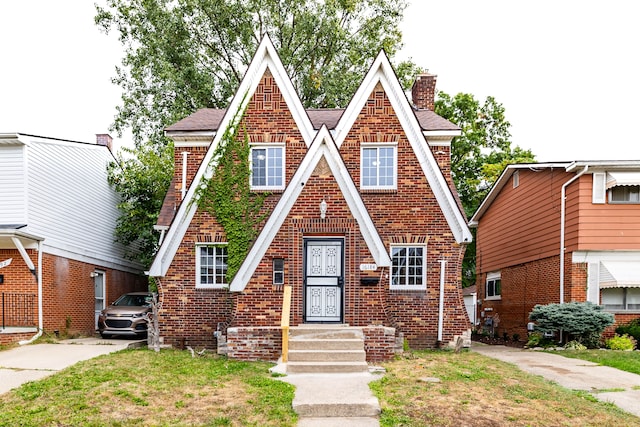 16184 Manor St, Detroit, MI 48221 - tudor-style house featuring a chimney, brick siding, and roof with shingles
