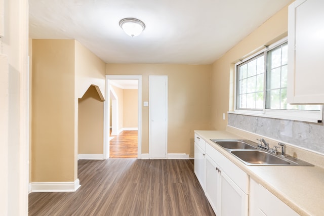 16184 Manor St, Detroit, MI 48221 - kitchen with a sink, dark wood finished floors, baseboards, light countertops, and white cabinetry