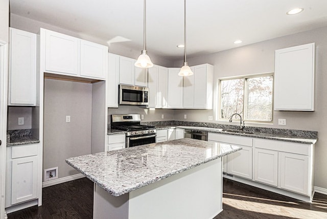 53207 Woodland Mdws, Chesterfield, MI 48047 - kitchen with light stone counters, stainless steel appliances, a sink, white cabinets, and a center island