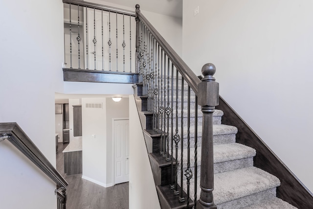 53207 Woodland Mdws, Chesterfield, MI 48047 - stairs with a towering ceiling, wood finished floors, visible vents, and baseboards