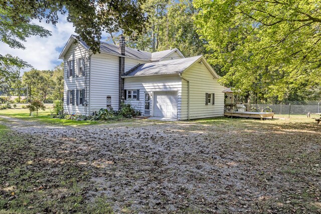10526 Spring Arbor Rd, Spring Arbor, MI 49283 - view of side of home with a garage, a chimney, and a wooden deck