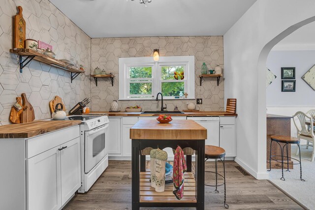 10526 Spring Arbor Rd, Spring Arbor, MI 49283 - kitchen with wooden counters, open shelves, a sink, white appliances, and arched walkways