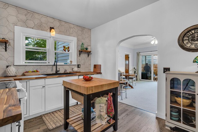 10526 Spring Arbor Rd, Spring Arbor, MI 49283 - kitchen featuring wood counters, a sink, range, arched walkways, and open shelves