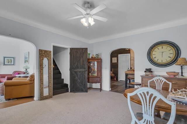10526 Spring Arbor Rd, Spring Arbor, MI 49283 - carpeted dining area with arched walkways, ceiling fan, and stairway