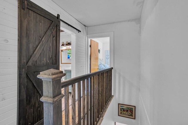 10526 Spring Arbor Rd, Spring Arbor, MI 49283 - hallway featuring a barn door and an upstairs landing