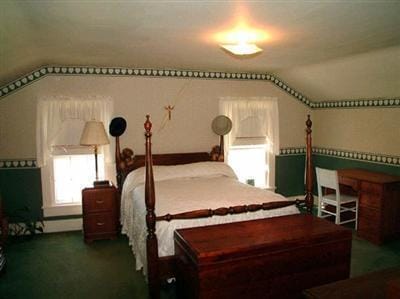 bedroom with dark carpet, vaulted ceiling, and baseboard heating