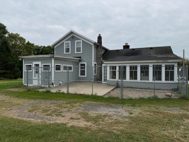 back of property with a patio area and a yard