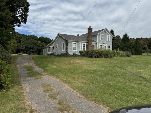 5295 Belding Rd NE, Rockford, MI 49341 - view of side of property with a chimney, a yard, and driveway