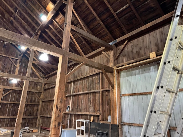 miscellaneous room featuring wood walls and lofted ceiling