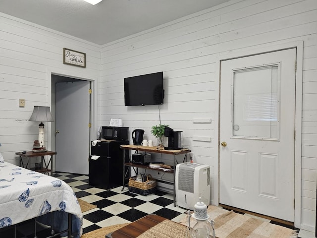 bedroom with hardwood / wood-style floors and wooden walls