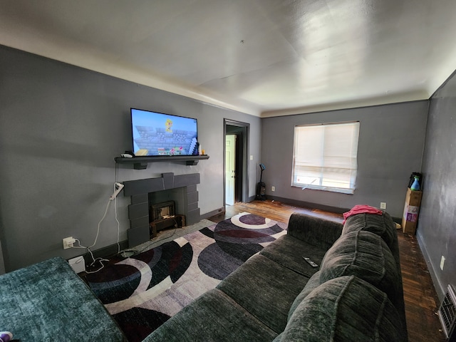 living room with hardwood / wood-style floors and a tiled fireplace