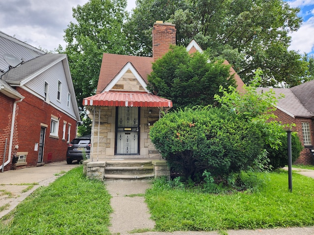 16510 Littlefield St, Detroit, MI 48235 - view of front of property featuring stone siding, a chimney, and concrete driveway