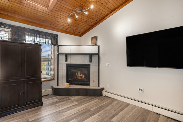 unfurnished living room featuring wood ceiling, a healthy amount of sunlight, vaulted ceiling, and a baseboard heating unit