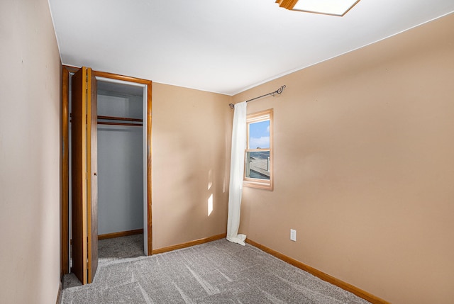 unfurnished bedroom with light colored carpet and a closet