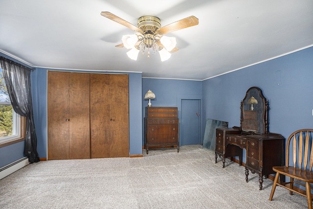 carpeted bedroom featuring a closet, baseboard heating, and ceiling fan