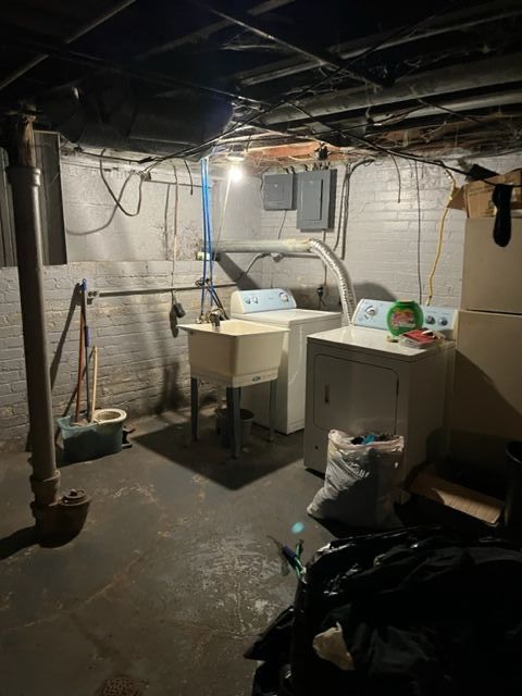 basement with electric panel, sink, and washer and dryer