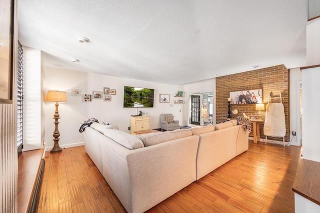 20616 Madison Ave, Big Rapids, MI 49307 - living room featuring light wood-style flooring, brick wall, and a textured ceiling