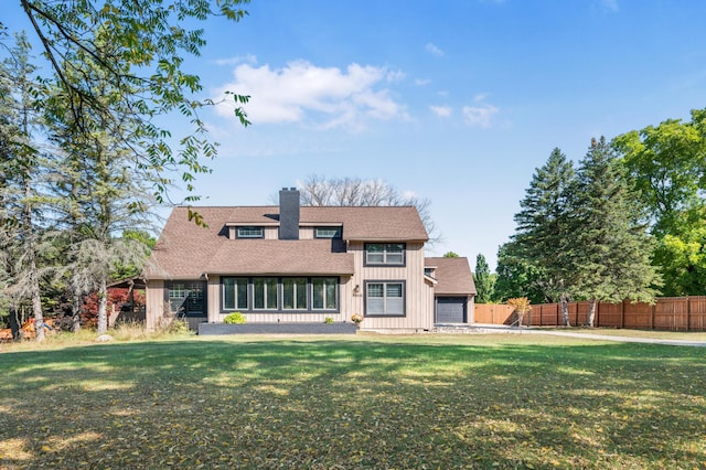 20616 Madison Ave, Big Rapids, MI 49307 - rear view of house with board and batten siding, a chimney, a garage, and roof with shingles