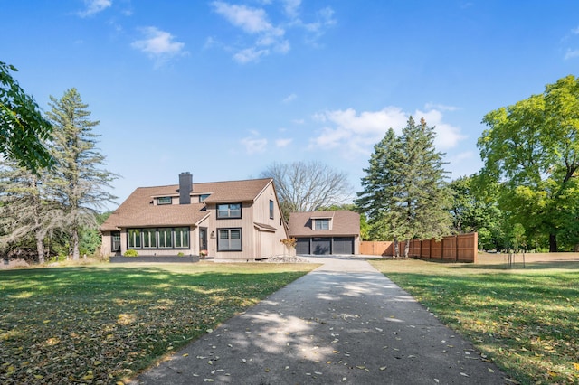 20616 Madison Ave, Big Rapids, MI 49307 - view of front facade with a chimney, a shingled roof, board and batten siding, and a garage