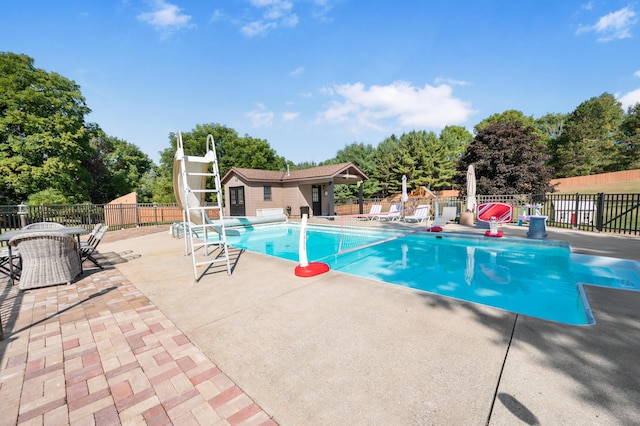 20616 Madison Ave, Big Rapids, MI 49307 - view of swimming pool featuring a water slide, a patio area, and view of wooded area