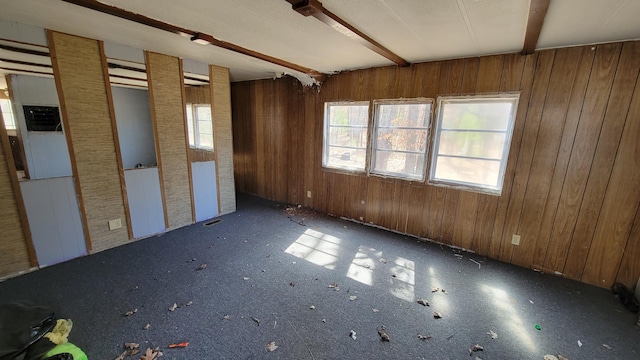 interior space with beam ceiling and wooden walls