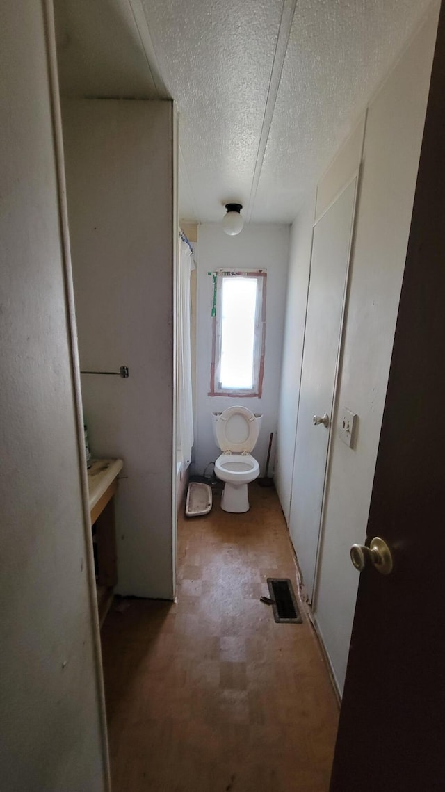 3376 Swihart Rd, Brethren, MI 49619 - bathroom with toilet, a textured ceiling, and a shower with shower curtain
