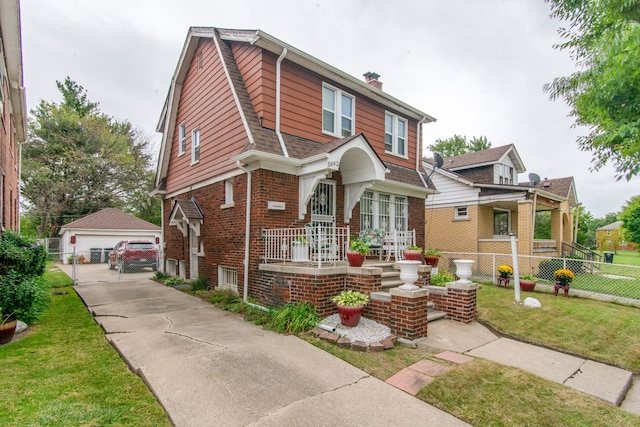 view of front of home featuring an outdoor structure, a porch, a front yard, and a garage