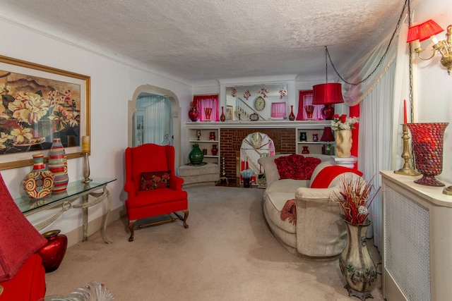 living area with carpet flooring, a textured ceiling, and a fireplace