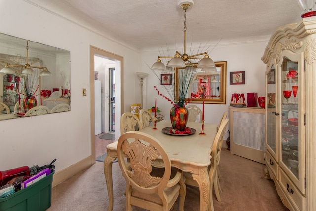 carpeted dining room featuring a chandelier and a textured ceiling