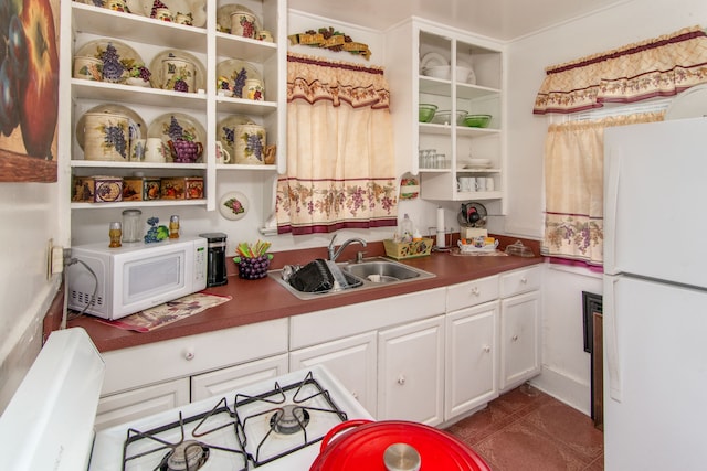 kitchen featuring sink, white cabinets, and white appliances