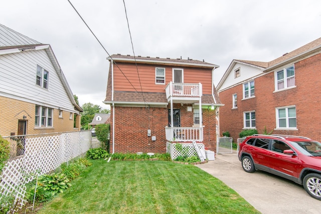 front of property with a balcony and a front lawn