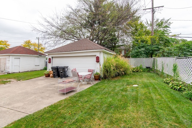 view of yard with a garage, an outdoor structure, and a patio