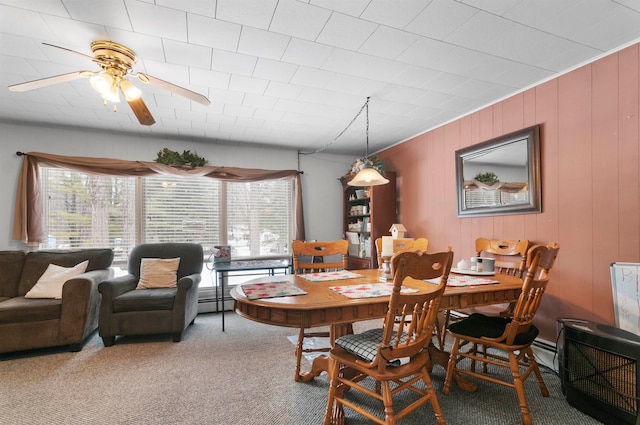 carpeted dining area featuring ceiling fan, baseboard heating, and a wealth of natural light