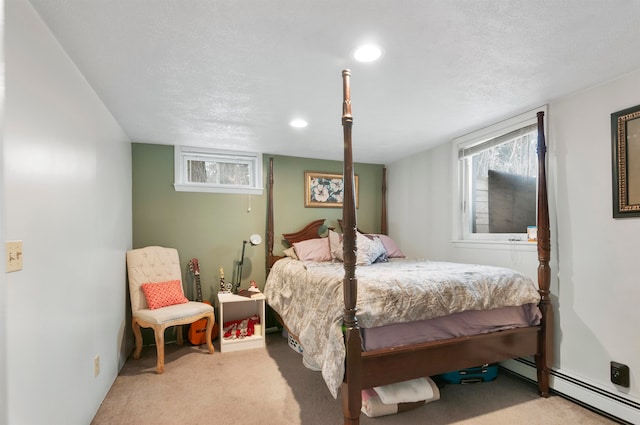 carpeted bedroom with a textured ceiling and a baseboard heating unit