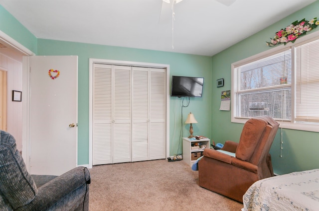 carpeted bedroom with ceiling fan and a closet