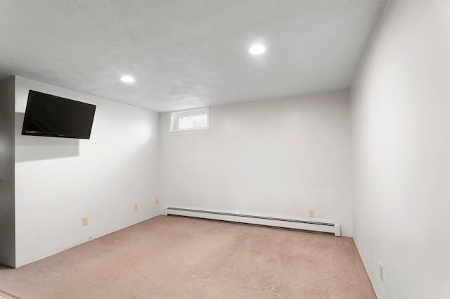 basement with light carpet, a textured ceiling, and baseboard heating