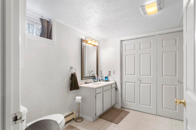 bathroom with tile patterned floors, vanity, a textured ceiling, and a baseboard heating unit