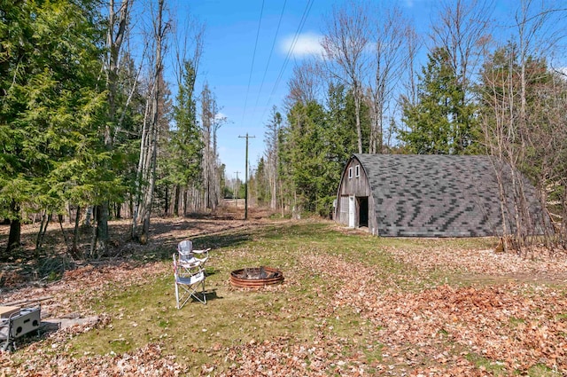 view of yard featuring a fire pit and an outdoor structure