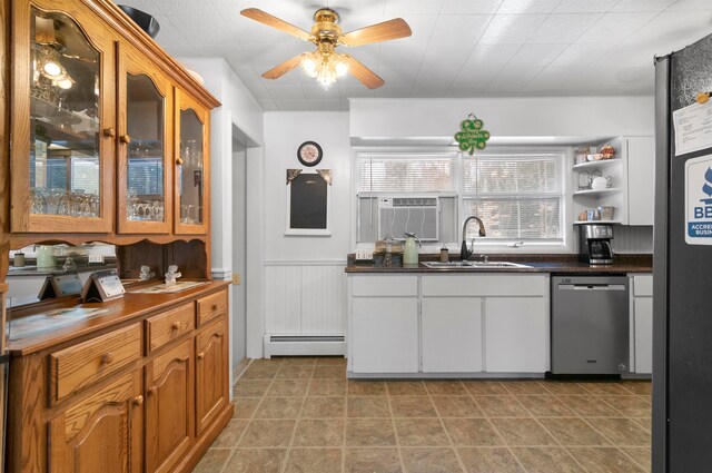 kitchen featuring ceiling fan, sink, baseboard heating, stainless steel dishwasher, and white cabinets