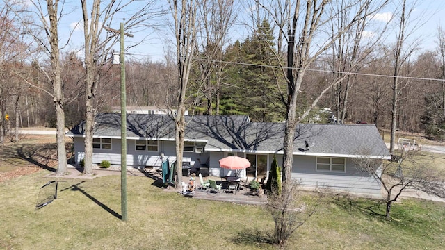 back of property with a patio area and a lawn