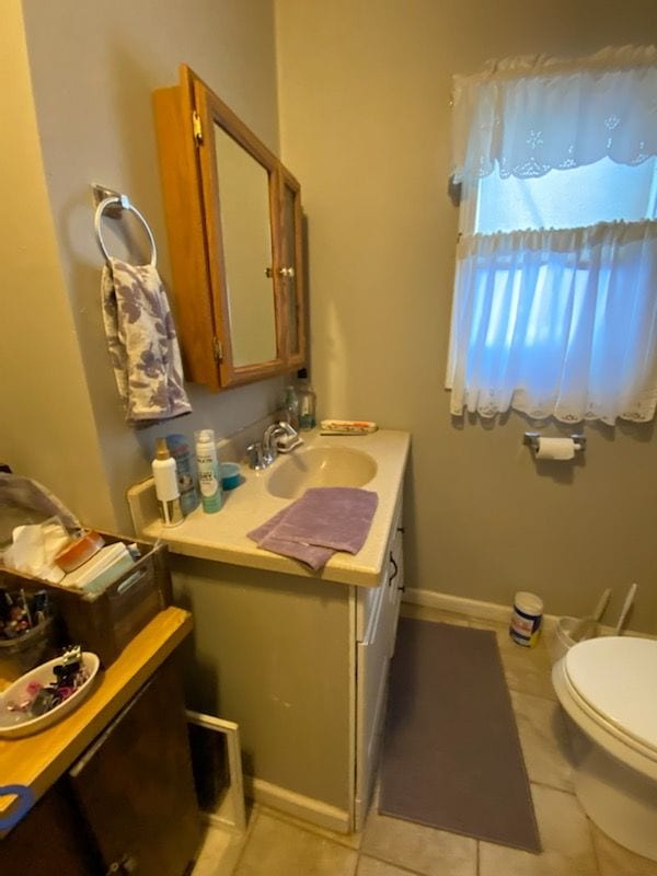 bathroom with tile patterned flooring, vanity, and toilet