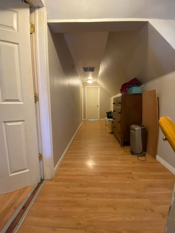 hall featuring light hardwood / wood-style flooring and vaulted ceiling