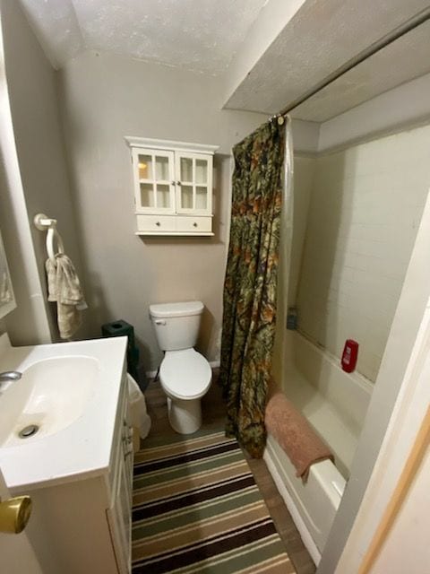 full bathroom featuring shower / bath combo with shower curtain, vanity, and toilet