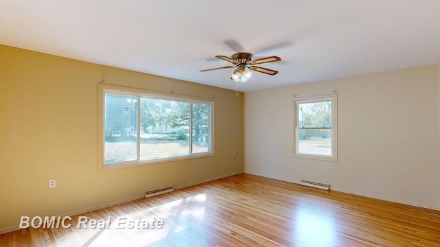 unfurnished room with ceiling fan, light hardwood / wood-style floors, and a baseboard heating unit