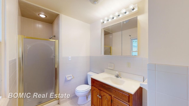 bathroom with tile patterned floors, walk in shower, vanity, tile walls, and toilet