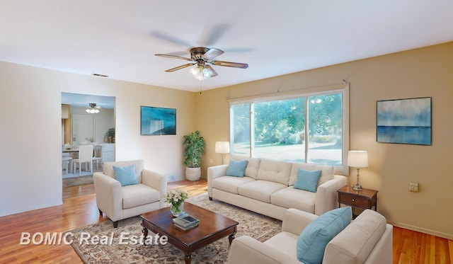 living room with light hardwood / wood-style floors and ceiling fan