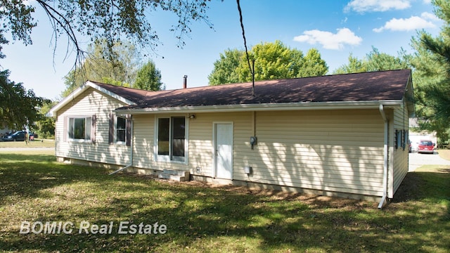 rear view of house featuring a yard