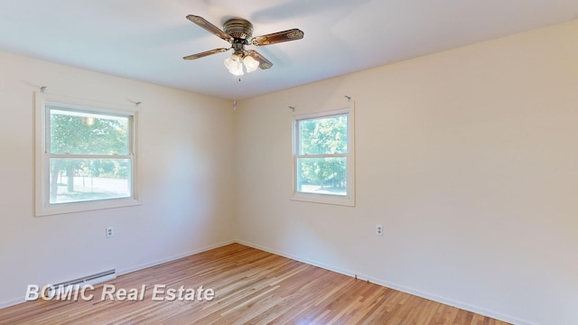 unfurnished room with light wood-type flooring, a wealth of natural light, a baseboard heating unit, and ceiling fan