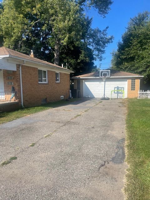 view of side of property featuring a yard, an outdoor structure, and a garage